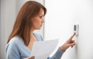 energy saving window film women adjusts thermostate