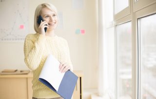 woman on phone looking out of office window