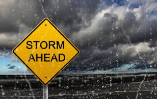 storm warning sign in front of ocean
