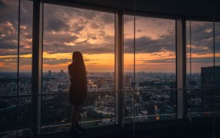 woman looking at city skyline at night