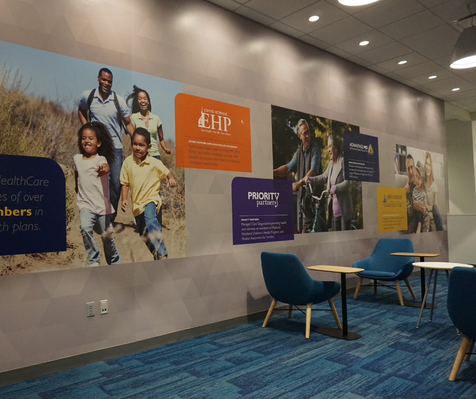 long wall mural with photos of family company values and logos with orange and purple accents
